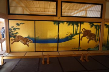 Golden leaf panels depicting tigers and a river