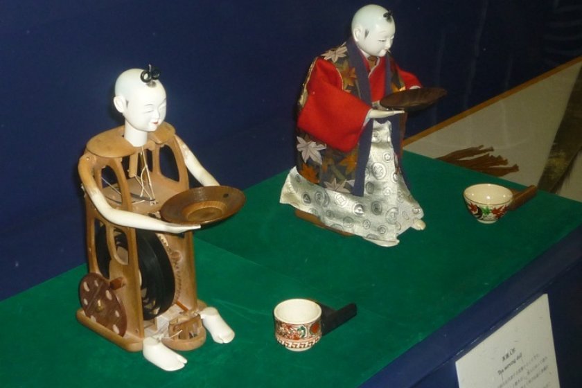 A stripped tea serving mechanical doll, and one fully clothed.