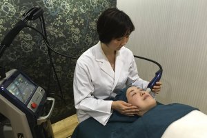 Dr. Naoko Hitosugi administering a skin treatment on a patient