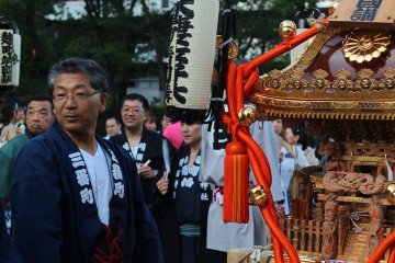 Standing by one of the many mikoshi (portable shrines)