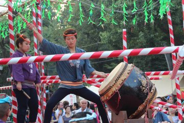 Taiko drummers perform onstage in the center of the festival grounds.