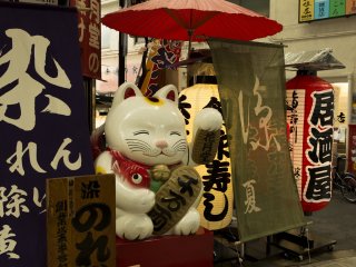 A Maneki Neko beckoning cat of such a size can only bring good fortune at Sennichimae arcade