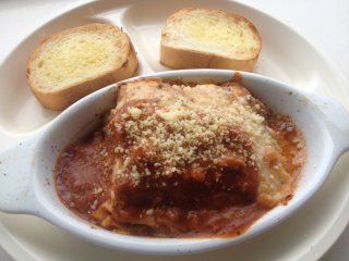 The lasagna and garlic bread set sprinkled liberally with parmesan cheese