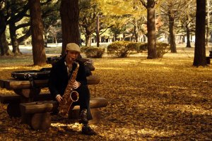 A saxophonist plays among the fallen ginkgo leaves at Yoyogi Park