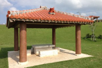 <p>There are a half dozen pavilions complete with red Ryukyuan tile roofs, a Shisha dogs, and concrete table and chairs</p>