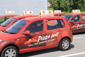 Pizza Hut vehicles on Kadena Air Base in Okinawa are driven by and deliver food prepared by bilingual contract workers