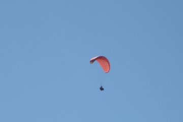 Paraglider floating in the blue sky