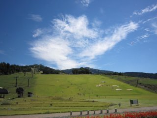 Turfy ski slope. Paragliders can be seen in the autumn, mackerel sky