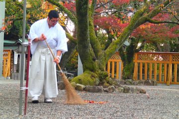 <p>A monk tidying the grounds before the morning visitors arrive</p>