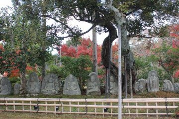 <p>The stone Buddhist statues rest near the pond</p>