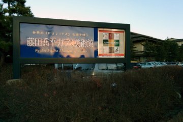 <p>ป้ายบนถนนของโรงแรม อิจิโนบะ ที่กำลังโฆษณาพิพิธภัณฑ์</p>