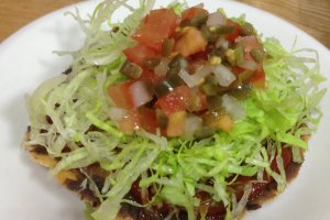 tostada with homemade salsa and refried beans