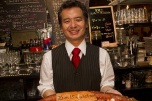 EZee Caf&eacute;オープン15周年記念プレゼントを受け取る店のオーナー、中川浩一氏