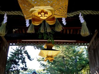 Ornate gold lanterns hang from the ceiling of the entrance gate